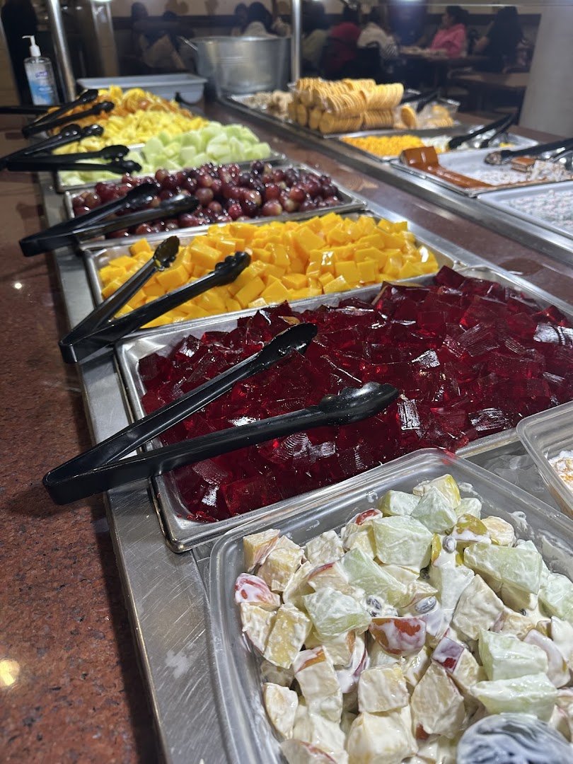 Salad bar and hot food line at a buffet.